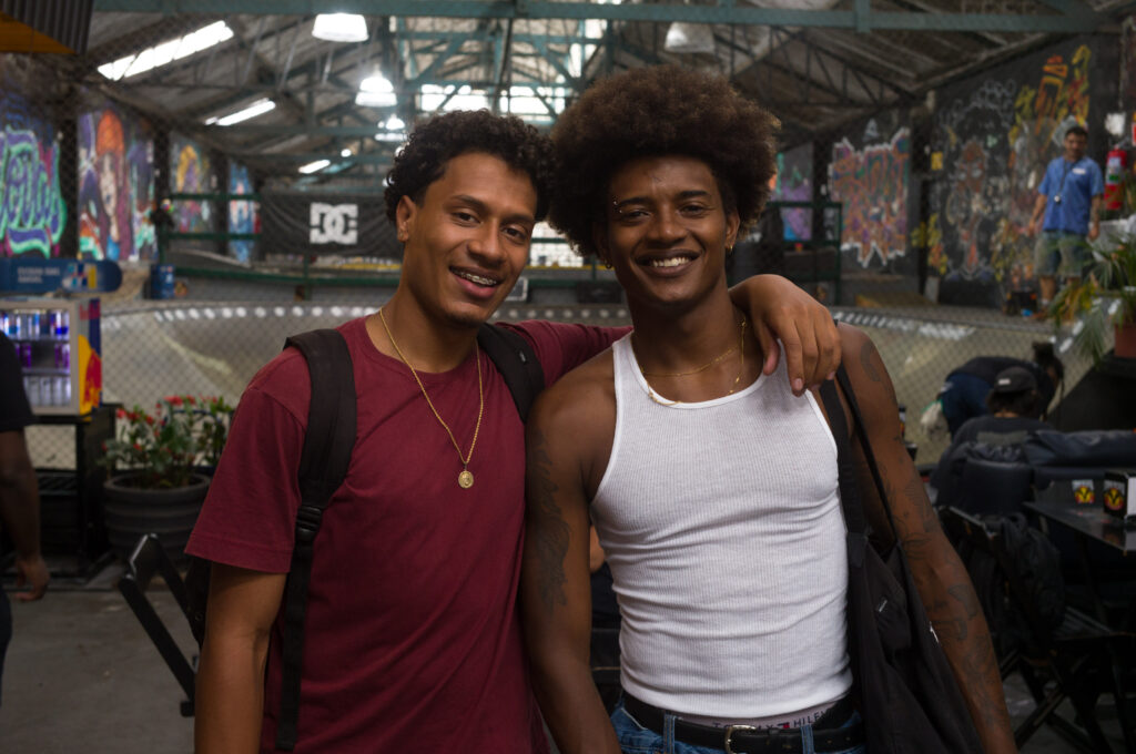 Two men smiling for the camera at a skatepark.